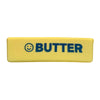 A yellow silicone squishy toy with the word BUTTER printed in dark blue text and a smiling face.