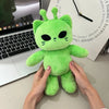 A hand is holding a bright green Kawaii Alien Cat plush toy against a white background.