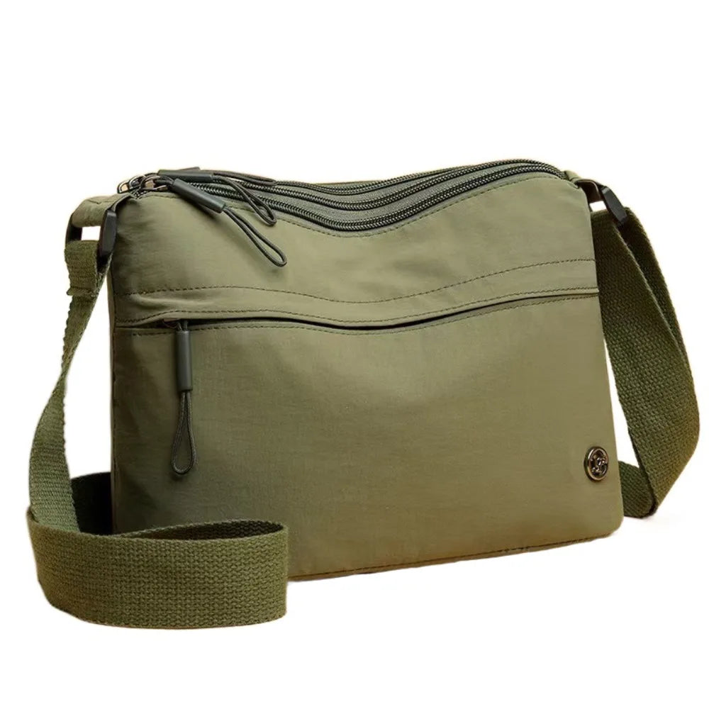 Olive green floral canvas tote bag with multiple zippered pockets and a matching strap