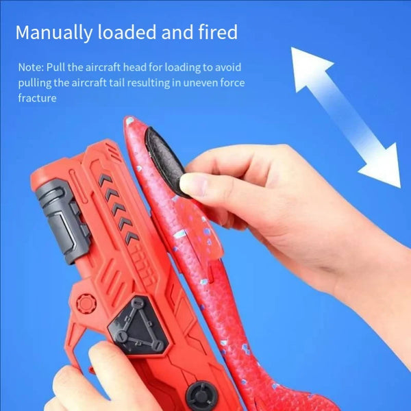 A hand is manually loading and firing an orange foam glider catapult toy gun for outdoor fun.