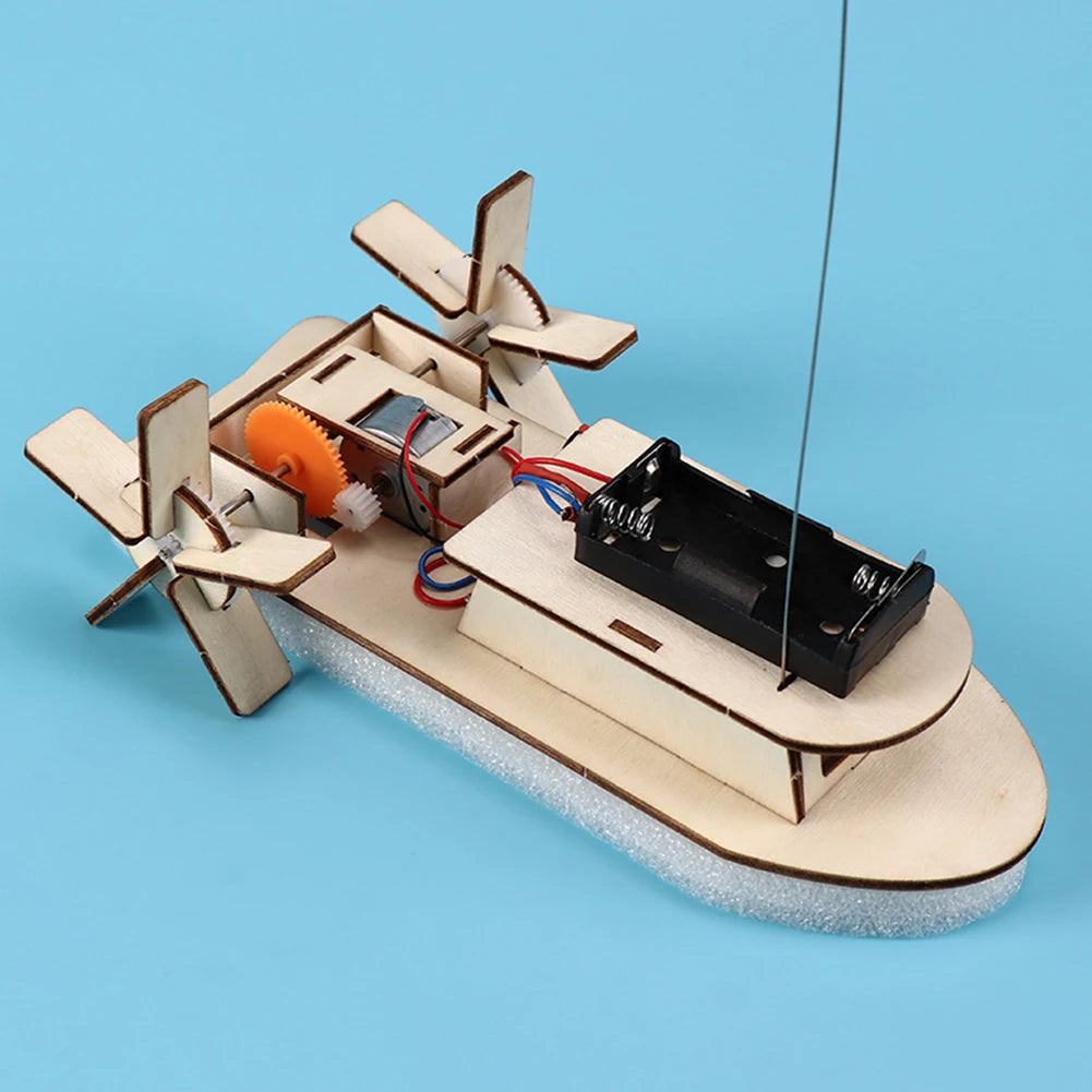 A wooden paddle boat model with sails and oars is shown on a light blue background.