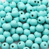 A pile of small, light blue wooden beads for jewelry making and DIY crafts.
