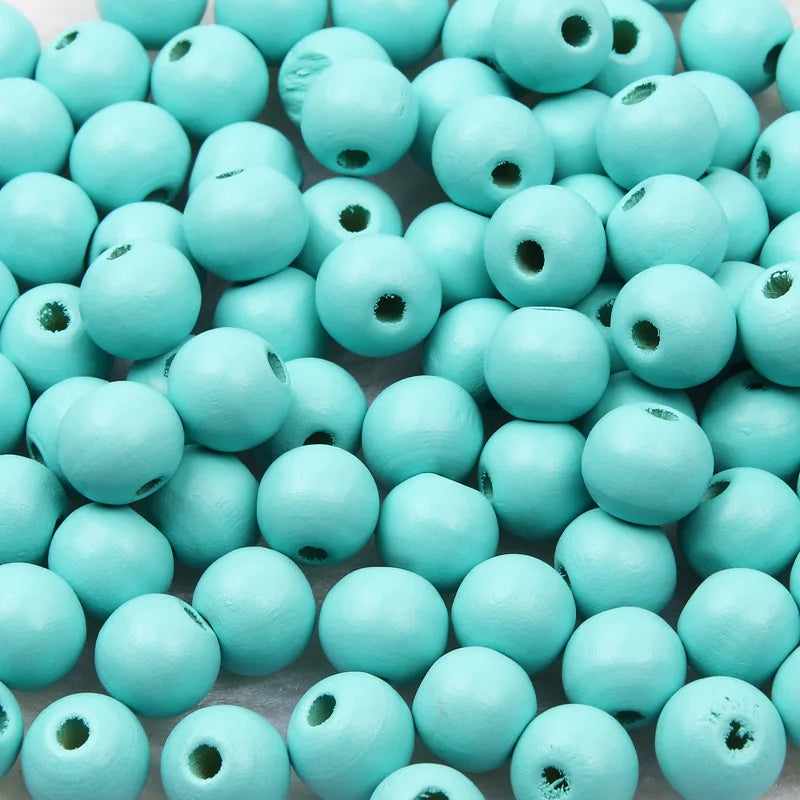 A pile of small, light blue wooden beads for jewelry making and DIY crafts.