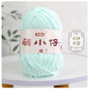 A ball of light mint green chenille yarn with a label in Chinese characters and a number 43