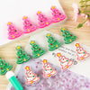 Pink and green Christmas tree silicone beads for jewelry making and DIY crafts displayed on a wooden surface.