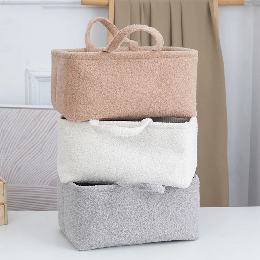Un ensemble de trois sacs multifonctionnels pour bébé, beige et gris, empilés verticalement.