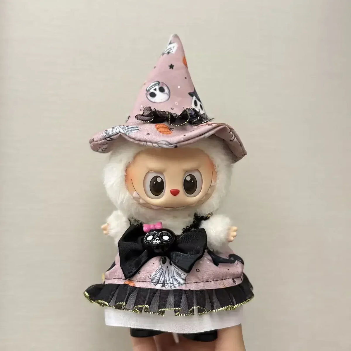 A handcrafted Halloween pumpkin costume set for a doll featuring a witch hat and black bow details.