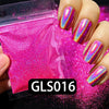 A hand holds a small plastic container of holographic pink nail glitter dust with vibrant rainbow sparkle.