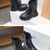 A pair of black girls' ankle boots with laces and an anti-skid rubber sole displayed on a white surface.