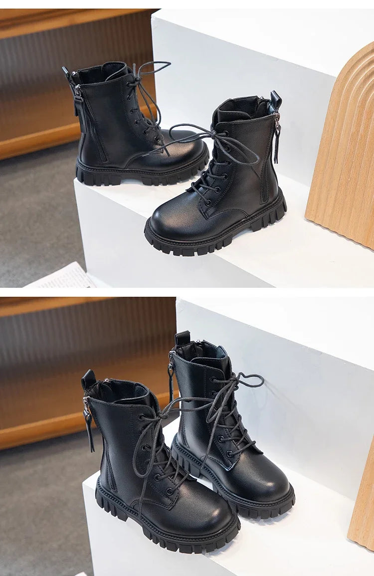 A pair of black girls' ankle boots with laces and an anti-skid rubber sole displayed on a white surface.
