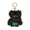 A black, furry monster plush with a goat-like face and a bone keychain attached to a leather loop.