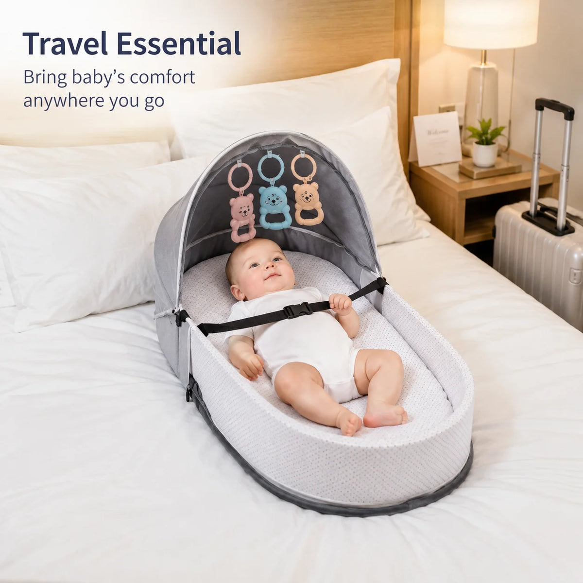 A portable foldable baby bed with a mosquito net and mattress is shown on a white bed.