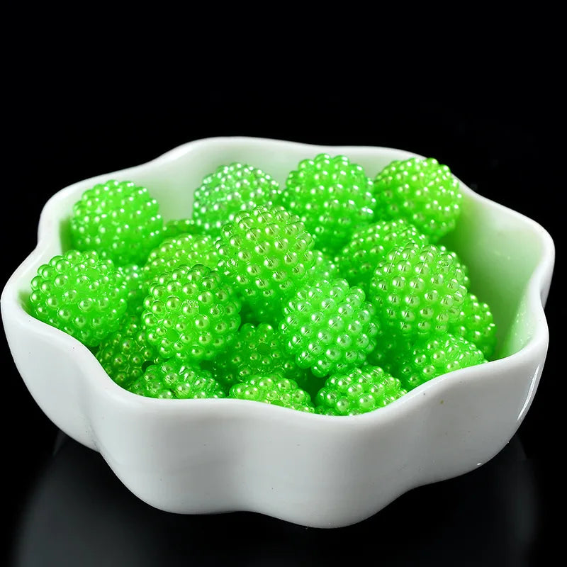 A white bowl filled with bright green acrylic pearl beads for jewelry making.
