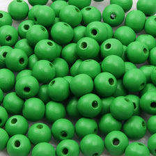 A pile of small, natural green wooden beads for jewelry making and DIY crafts.