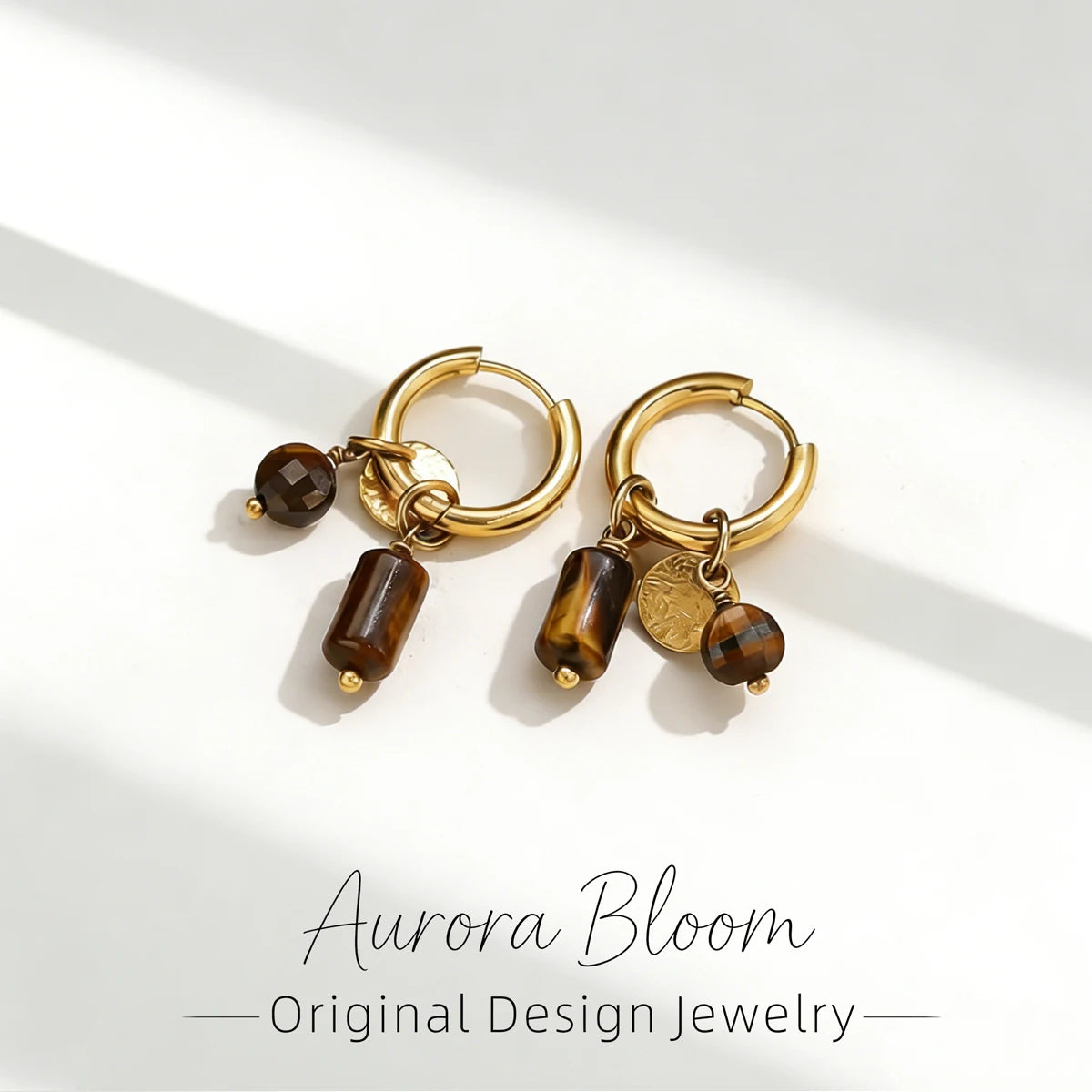 Gold hoop earrings featuring tiger's eye stone beads and charms