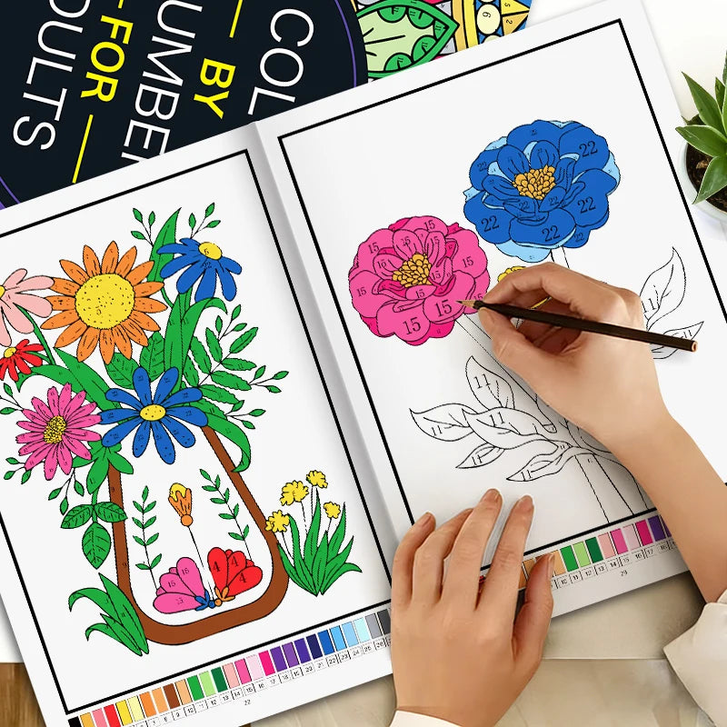 A hand is coloring a page from a color by number book featuring floral designs with colored pencils.