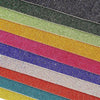 A close-up view of various colored sparkling rhinestone adhesive tape strips stacked diagonally.