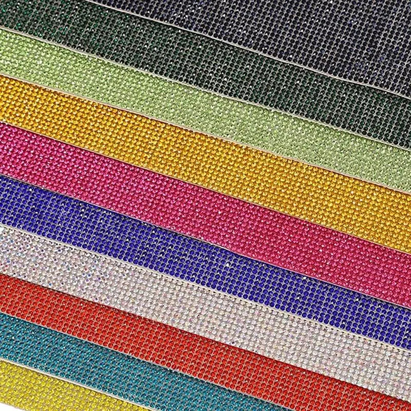 A close-up view of various colored sparkling rhinestone adhesive tape strips stacked diagonally.