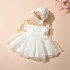A white lace tulle dress for a newborn baby girl is displayed with a matching lace hat on a neutral background.