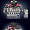 A detailed model of a motorized V8 engine building block set with electric drive, featuring silver and red components.