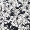 A close-up view of small, round pony beads in various colors including white, black, and clear/translucent.