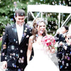 A bride and groom walk through sparkling bubbles during their celebration.