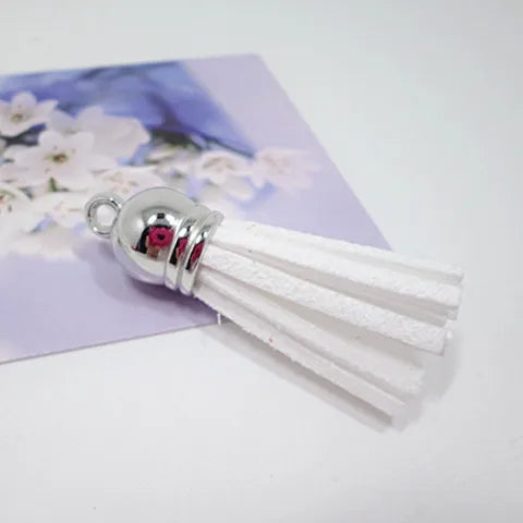 White velvet tassels with silver metal tips displayed on a purple floral background