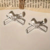 Two clear acrylic bow tie beads are displayed on a white surface.