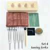 A set of four tuning forks made of metal and wood for sound healing and meditation.