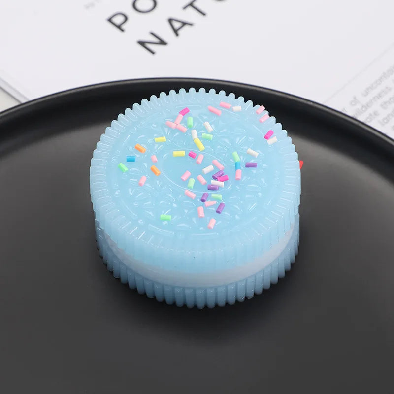 A light blue squishy stress relief toy with colorful confetti on a dark plate.
