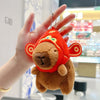 A fluffy orange capybara plush toy is being held in a person's hand.
