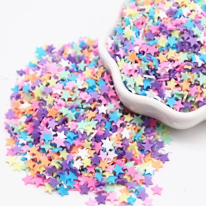 A pile of colorful polymer clay sprinkles in various shades of pink, purple, blue, and yellow stars.