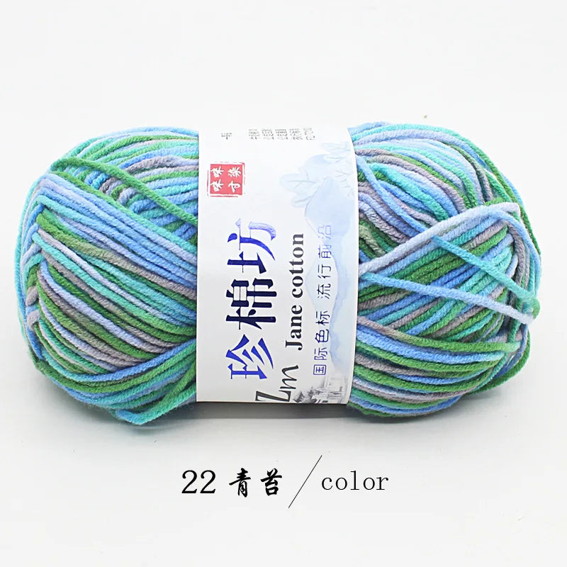 A ball of multi-colored yarn featuring shades of blue, green, and gray for knitting and crochet.