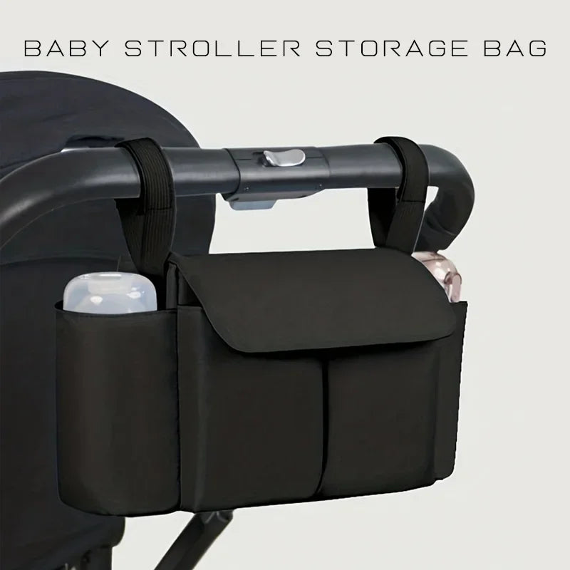 A black baby stroller storage bag is attached to a stroller handlebar.