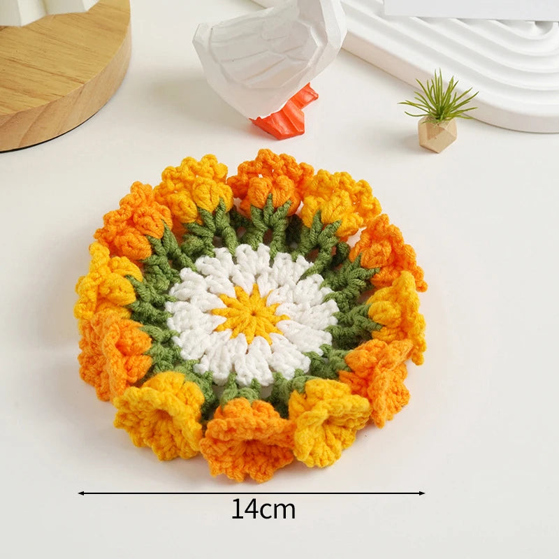 Hand-crocheted orange and white lily of the valley coasters with green accents