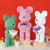 A set of pink and white flower bear building blocks made with micro bricks on a wooden base.