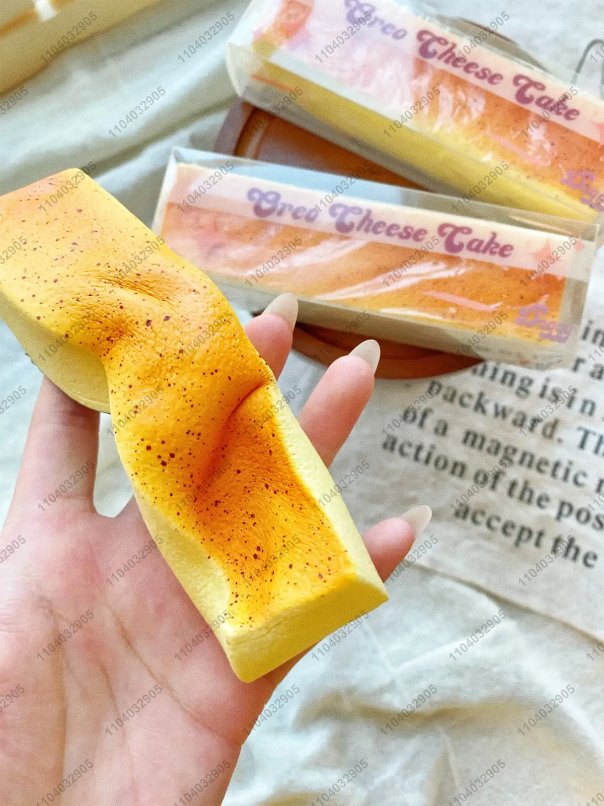A hand holds a yellow butter stick squishy toy with orange and yellow coloring, next to packaged versions.