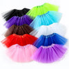 A collection of colorful three-layer tutu skirts for girls in shades of black, purple, green, blue, white, and pink.