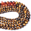 A close-up of natural yellow tiger eye stone beads arranged in a curved line for jewelry making