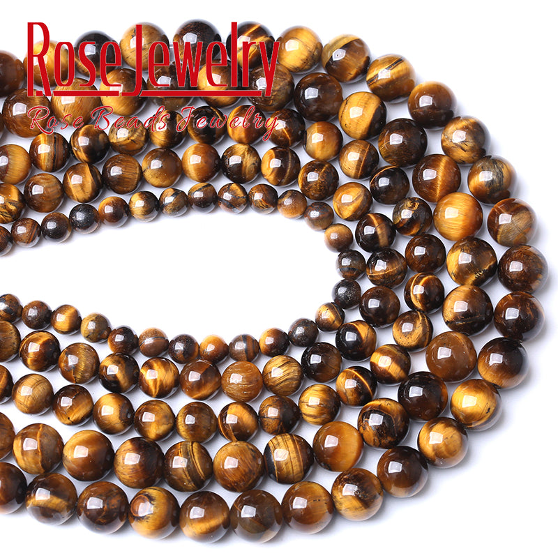 A close-up of natural yellow tiger eye stone beads arranged in a curved line for jewelry making