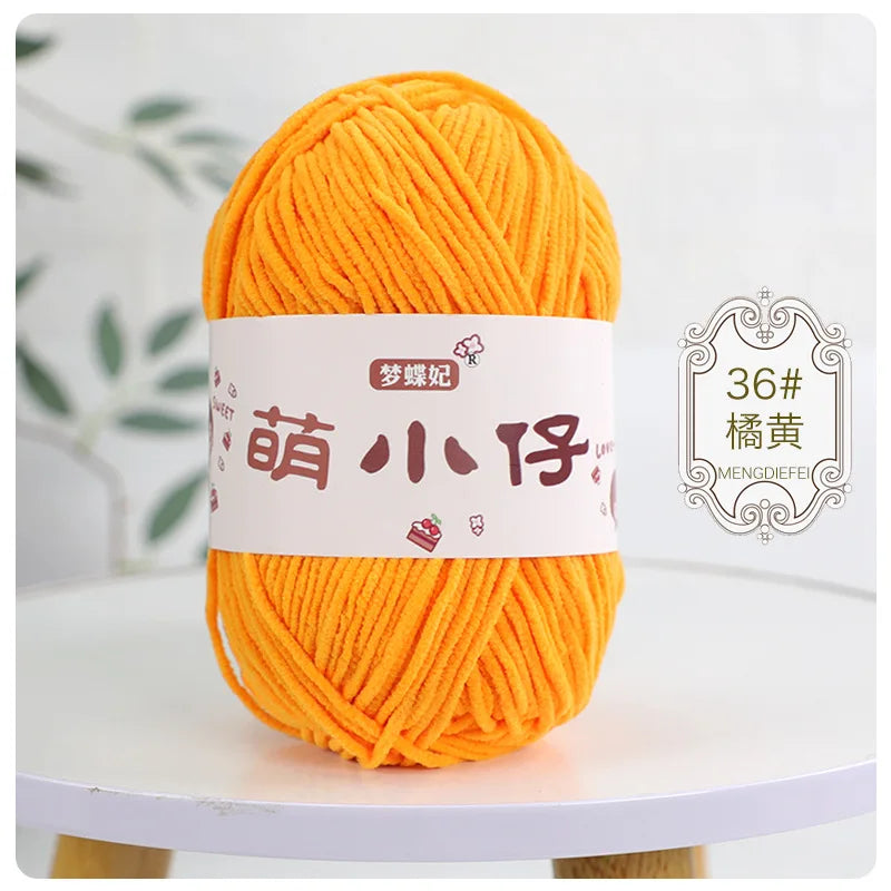 A ball of bright orange chenille yarn labeled with Chinese characters for knitting and crochet.