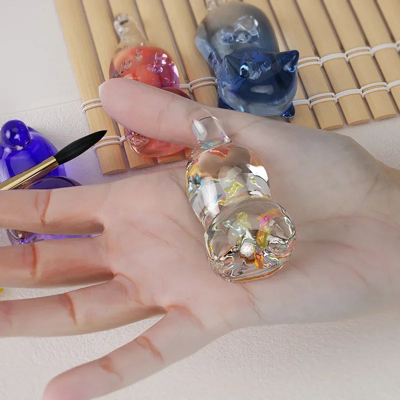 A hand holds a clear resin mold with a cat shape, next to other colorful resin molds and bamboo slats.