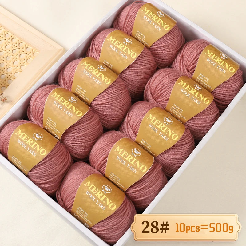 A box of Merino wool yarn balls in a pinkish-rose color, labeled for knitting projects.
