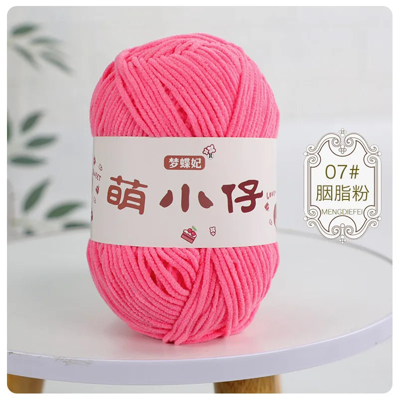 A ball of bright pink chenille yarn labeled with Chinese characters for knitting and crochet.
