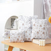 A set of three white waterproof bags with a gold and brown design for storing swimsuits, diapers, or travel items.
