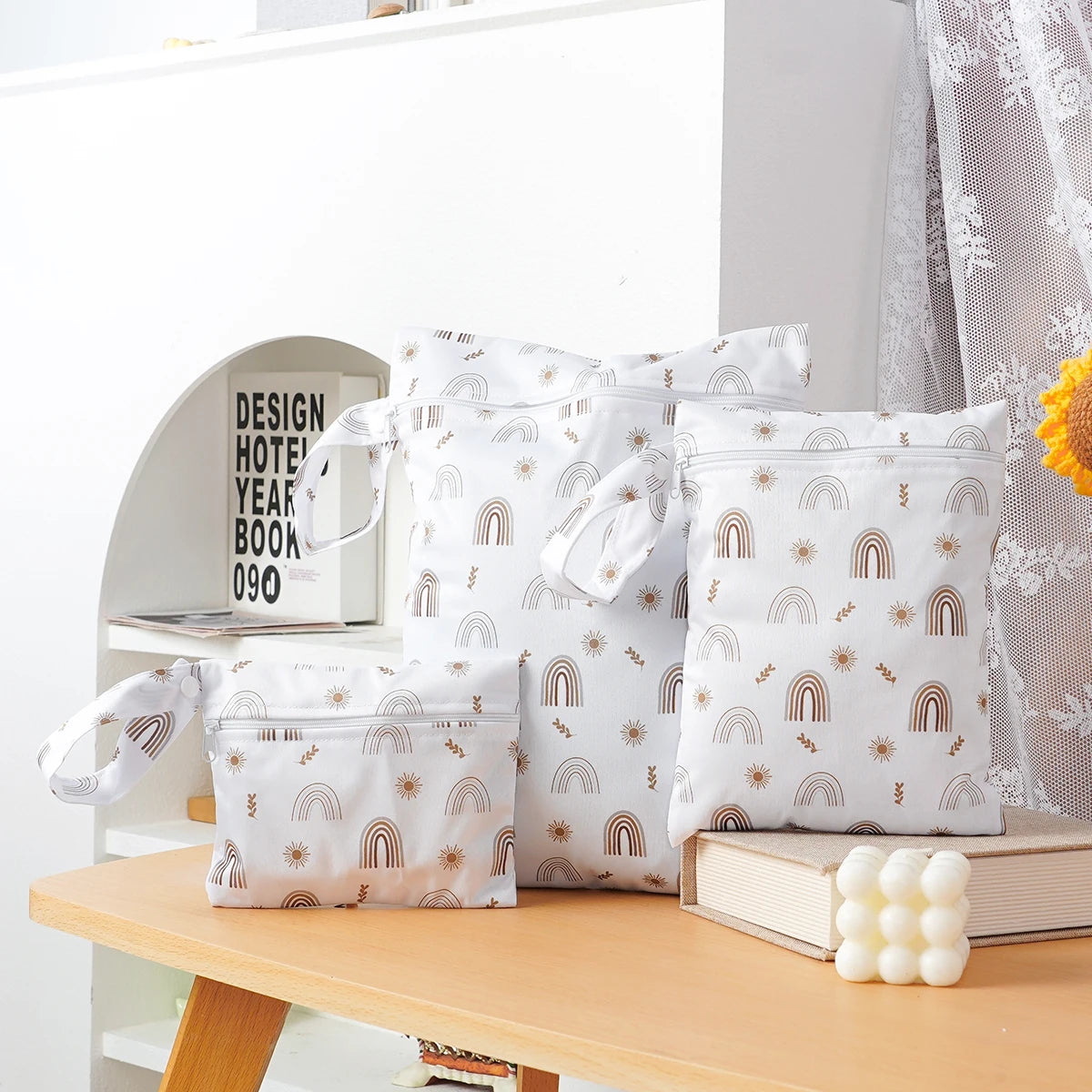 A set of three white waterproof bags with a gold and brown design for storing swimsuits, diapers, or travel items.