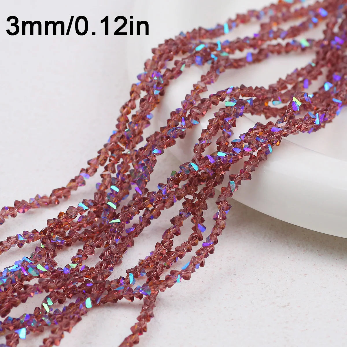 A close-up of reddish-brown crystal triangle beads, 3mm long, strung together for jewelry making.