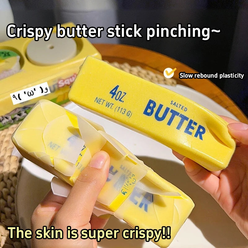 A hand is pinching a yellow butter stick fidget toy, showing its crispy skin texture.
