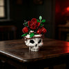 A set of gothic floral skull building blocks featuring red roses and green leaves displayed on a dark wooden table.