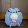 A light blue plush cat doll with pink and white striped accents, shown against a brown background.